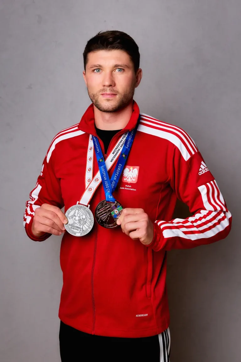 mistrz z medalami na szyji w czerwonej bluzie