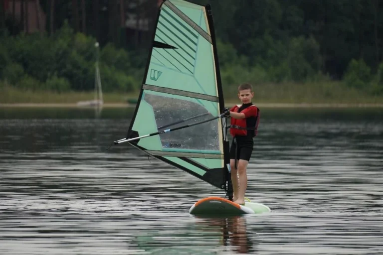 chlopiec zaglujacy na desce do windsurfingu