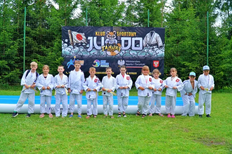 dzieci z strojach judo na tle plakatu tanuki